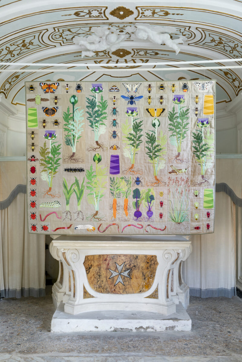 Image of Embroidered quilt with artichoke plants, green stinkbugs, cockchafer beetle larvae, earthworms, swallowtail butterfly caterpillar, greenbottle fly, honey bees, bumble bees, magpie moth, cockchafer beetle, peacock butterfly, meadow fescue grass, mottled grasshopper, red-tailed bumblebee, ladybirds, carpenter bee, swallowtail butterfly, cauliflower cabbage plant, red admiral butterfly, pet-saï cabbage plant, cabbage white butterfly, bluebottle fly, striped shield bug, red crimson underwing moth, jersey tiger moth, firebugs, red admiral butterfly caterpillar, Parnassius apollo butterfly, cinnabar moth, clouded orange butterfly and bobbins by PLANTING SCULPTURES, SCULPTING PLANTS